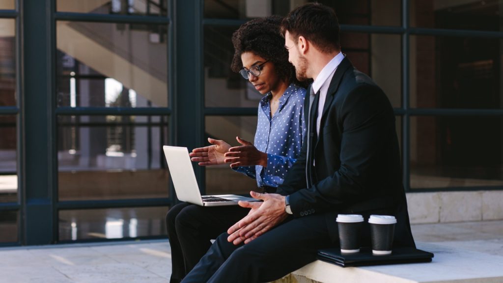 adult students in front of laptop sitting outside